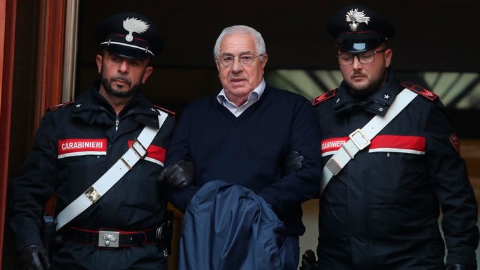 Policajti eskortujú  údajného bossa sicílskej mafie Cosa Nostra Settimo Minea, ktorého zatkli v palerme.