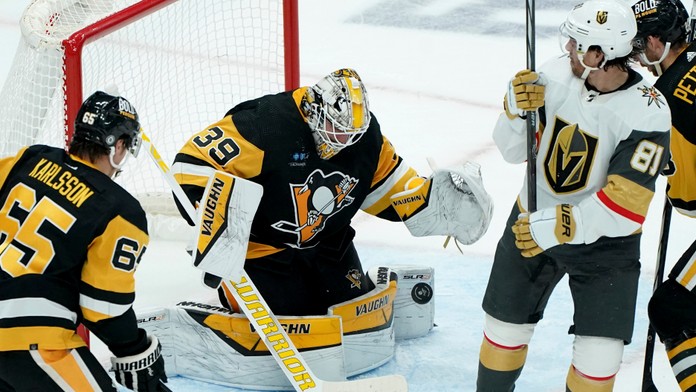 Na snímke druhý zľava brankár Penguins Alex Nedeljkovic chytá puk.