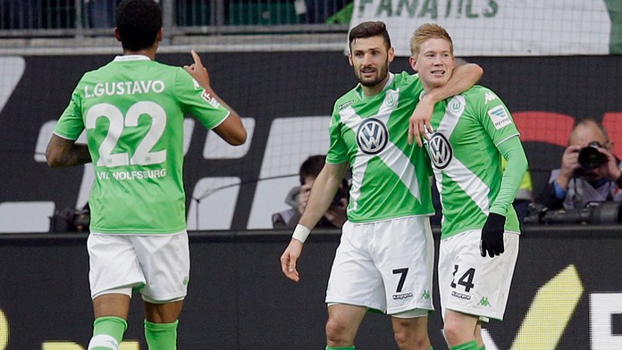 Wolfsburgčan Kevin de Bruyne (pravo) sa raduje so spoluhráčmi Danielom Caligiurim a Luizom Gustavom v zápse 25. kola proti Freib