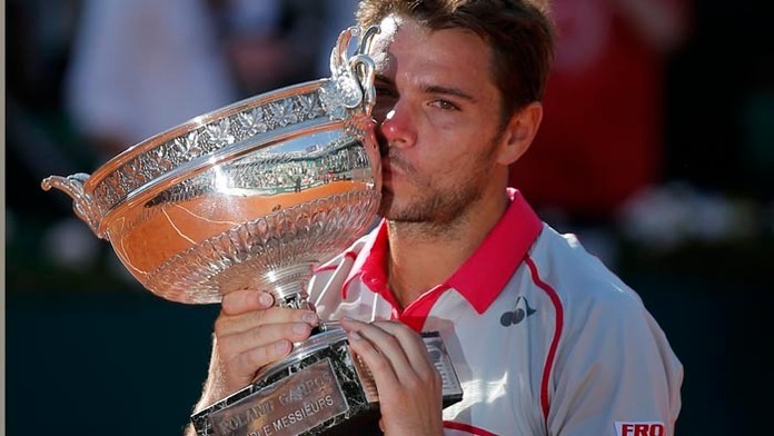 Švajčiar Stan Wawrinka bozkáva trofej po víťazstve proti Srbovi Novakovi Djokovičovi vo finále mužskej dvojhry na grandslamovom 