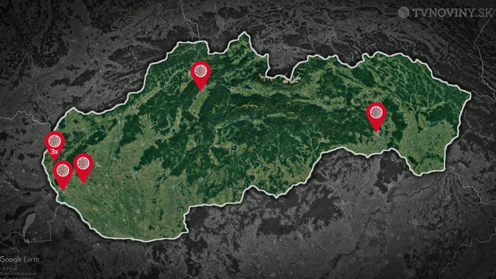 Zdravotník v ochrannom odeve meria teplotu cestujúcej v automobile na hraničnom priechode.
