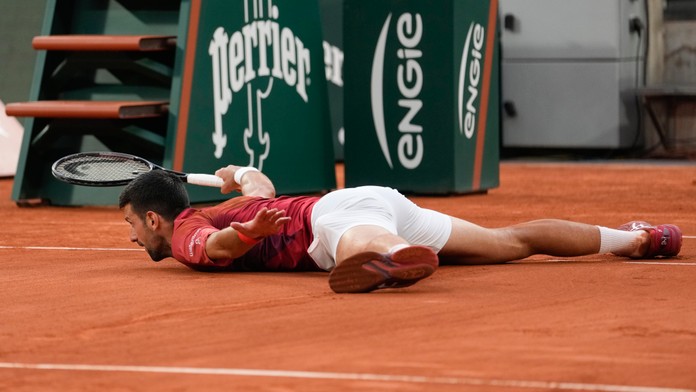 Na snímke srbský tenista Novak Djokovič leží na dvorci.