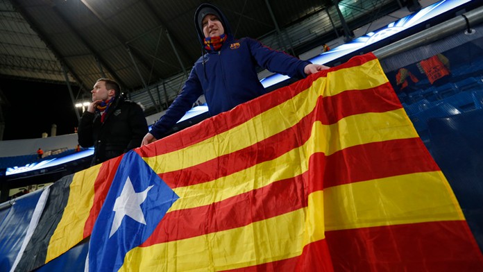 Na archívnej snímke fanúšikovia Barcelony vešajú katalánsku zástavu pred futbalovým zápasom ich klubu.