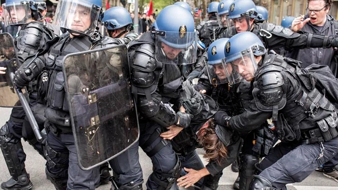 Poriadková polícia odvádza zadržaného demonštranta počas protestu proti plánovaným reformám.