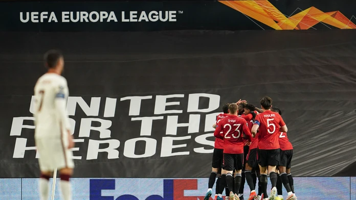 Hráč Manchesteru United Bruno Fernandes oslavuje so spoluhráčmi úvodný gól do bránky AS Rím.