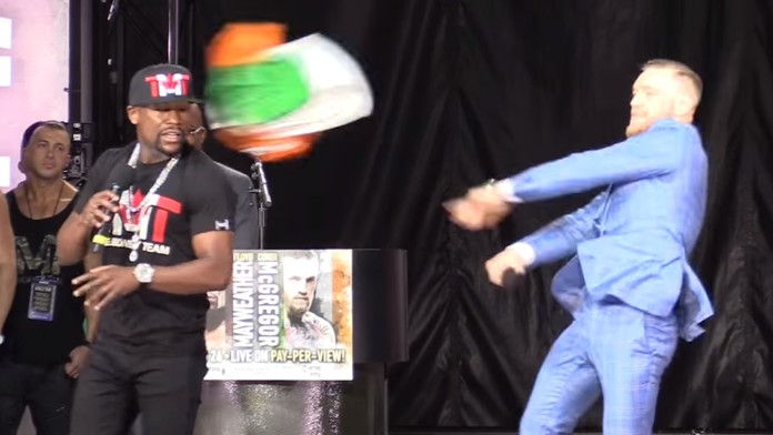 Conor McGregor hádže do tváre Floyda Mayweathera írsku vlajku.