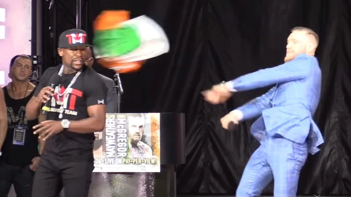 Conor McGregor hádže do tváre Floyda Mayweathera írsku vlajku.