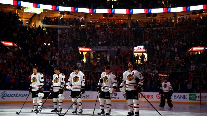 Hráč Chicaga Blackhawks Marián Hossa (vľavo) so spoluhráčmi si uctili obete piatkových teroristických útokov v Paríži pred zápas