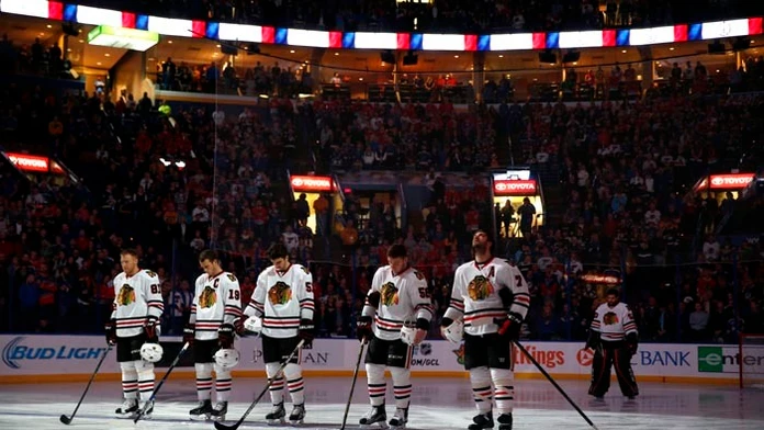 Hráč Chicaga Blackhawks Marián Hossa (vľavo) so spoluhráčmi si uctili obete piatkových teroristických útokov v Paríži pred zápas