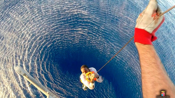 Pomocou lana zachraňujú z mora migranta v Stredozemnom mori medzi Líbyou a Talianskom. 12. augusta