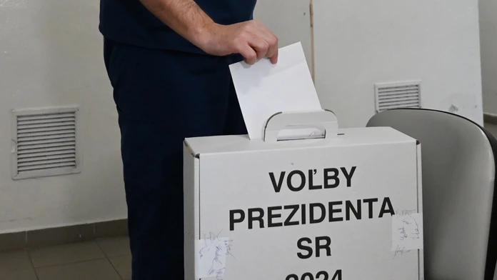 Na snímke lekár Fakultnej nemocnice Trnava vhadzuje obálku s hlasovacím lístkom do prenosnej volebnej schránky.