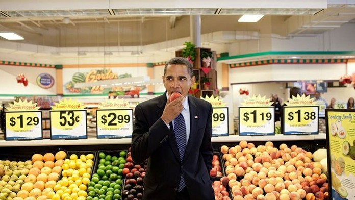 Prezident Obama skúša jablko v supermarkete.