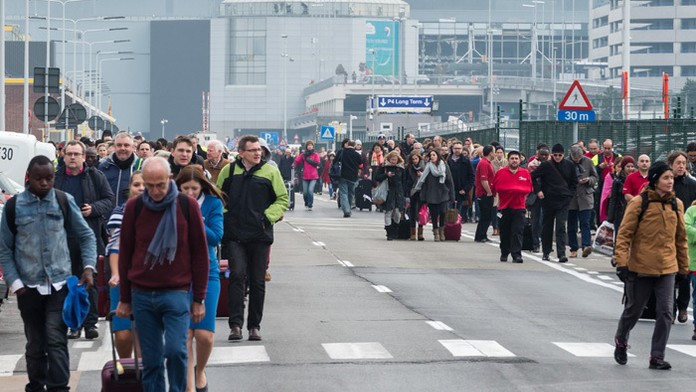 Ľudia odchádzajú z bruselského letiska Zaventem po explózii.