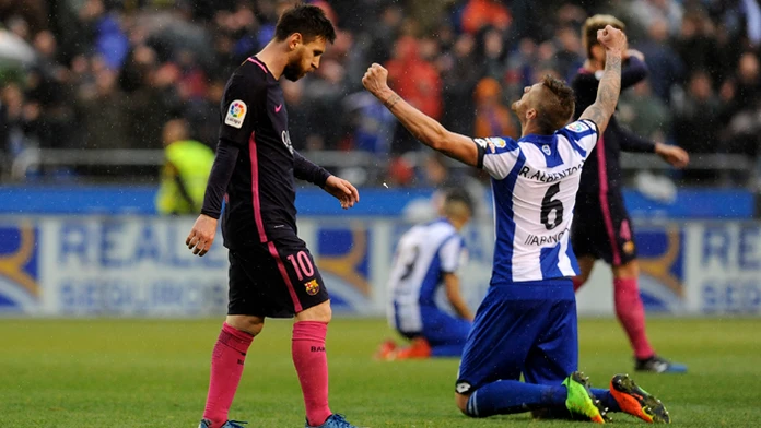 Lionel Messi (Barcelona) a vpravo hráč Deportivo Raul Albentosa.