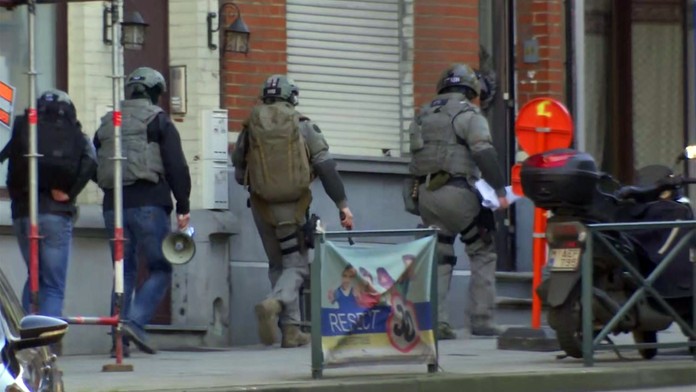 Belgické bezpečnostné zložky zasahujúce v jednej z bruselských štvrtí. 