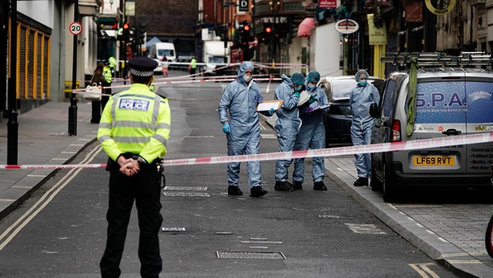 Forenzní expeerti a policajti na mieste útoku na dvoch policajtov v Londýne.