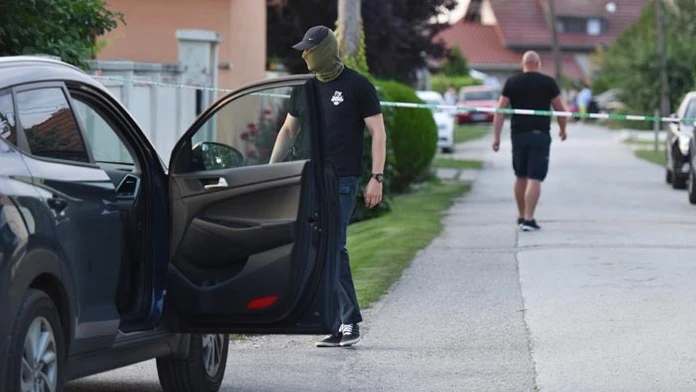 Policajt pri dome zavraždeného novinára. 