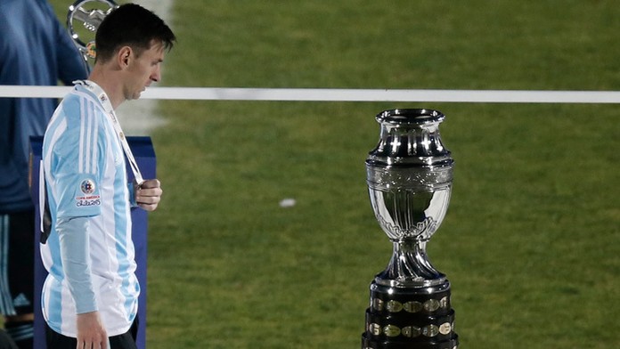 Lionel Messi smutne pozerá na víťaznú trofej Copa America.