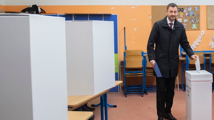 Premiér Eduard Heger vhadzuje obálku s hlasovacími lístkami do volebnej schránky pre komunálne voľby.