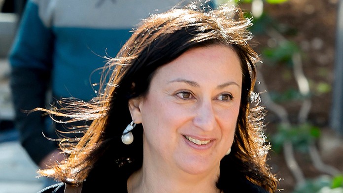 Umelec maľuje portrét Georgea Floyda počas pokračujúcich protestov v USA.