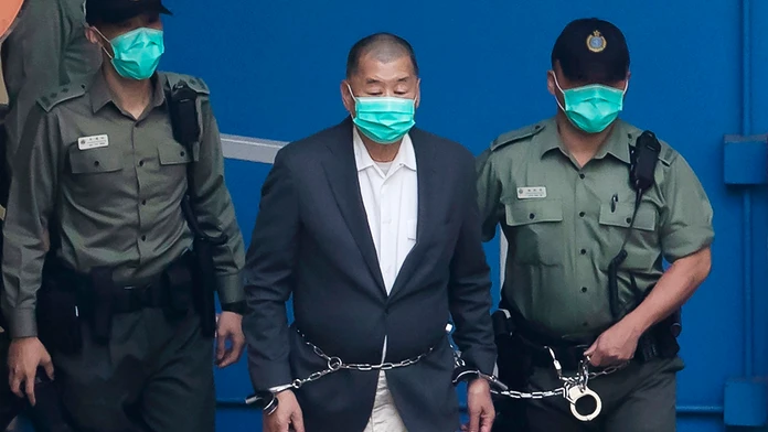 Jimmyho Laia privádzajú policajti v putách na súd v Hongkongu.