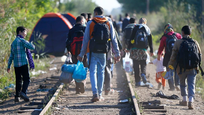  Migranti, ktorí  opustili záchytný tábor pre utečencov, kráčajú pešo popri železničnej trati pri obci Röszke na juhu Maďarska, 