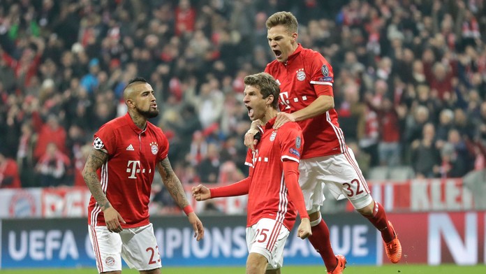 Thomas Müller (v strede) z Bayernu jasá po svojom góle v osemfinále LM proti Arsenalu, vľavo Arturo Vidal a vpravo Joshua Kimmic