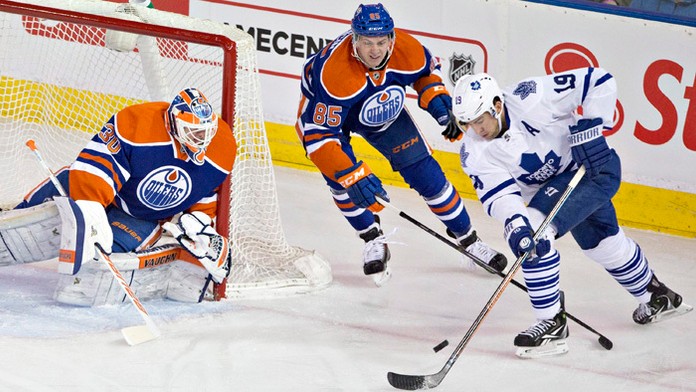 Joffrey Lupul (Toronto) sa snaží dať gól do brány cez Martina Marinčina (Edmonton).