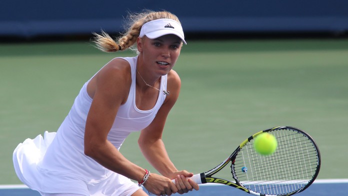 Dánska tenistka Caroline Wozniacka  odvracia loptičku Slovenke Magdaléne Rybárikovej v 1. kole turnaja v Cincinnati.