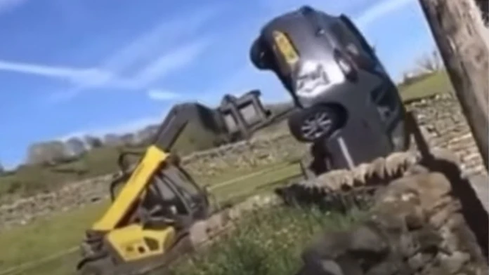 Farmár nabral auto s traktorom s vysokozdvižnou vidlicou.