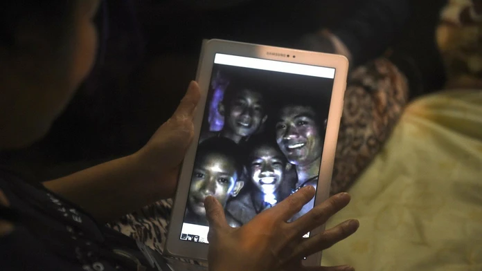 Mama jedného z chlapcov drží tablet s fotografiou, ktorú urobili potápači.