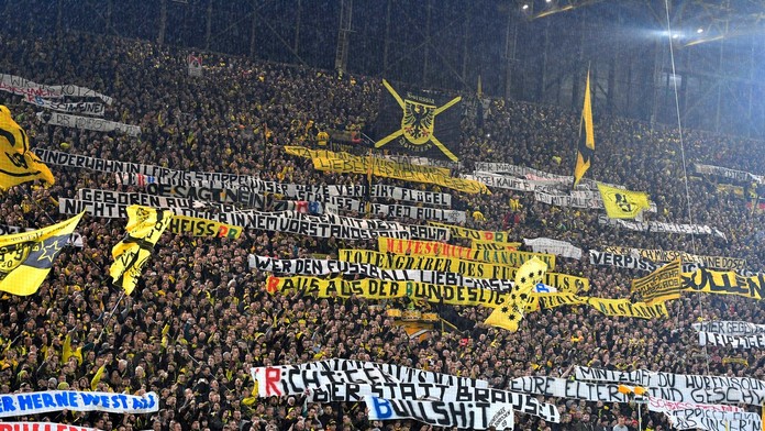 Priaznivci Borussie Dortmund s transparentmi proti tímu RB Lipsko.