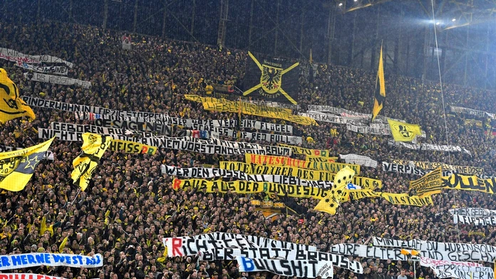 Priaznivci Borussie Dortmund s transparentmi proti tímu RB Lipsko.