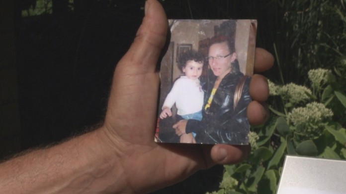 Starý otec ukazuje fotku, na ktorej je Miško s mamou Veronikou.