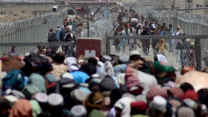 Ľudia, ktorí opustili svoje domovy  prechádzajú cez hranicu.