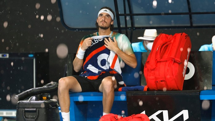 Grécky tenista Stefanos Tsitsipas sedí na lavičke počas prerušenia zápasu kvôli dažďu vo štvrťfinále mužskej dvojhry.