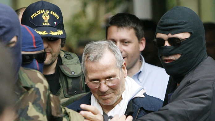 Na archívnej snímke z 11. apríla 2006 kukláči privážajú  Bernarda Provenzana na policajnú stanicu v Palerme
