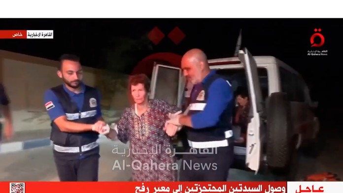Na videosnímke prepustená rukojemníčka Jocheved Lifšicová v sprievode členov Červeného kríža na hraničnom priechode Rafah.