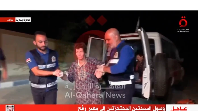 Na videosnímke prepustená rukojemníčka Jocheved Lifšicová v sprievode členov Červeného kríža na hraničnom priechode Rafah.
