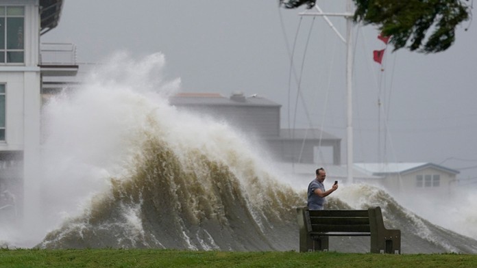 Muž si fotí vysokú vlnu pri probreží počas hurikánu Ida v americkom meste New Orleans.