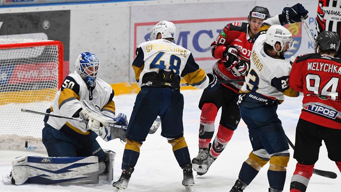 Hokejisti bojujú o puk pred brankárom Slovana Clintom Windsorom v dueli proti HC Grotto Prešov.