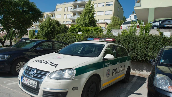 Odstavené policajné auto pred bytovkou, v ktorej sídli niekoľko firiem podnikateľa Bašternáka.