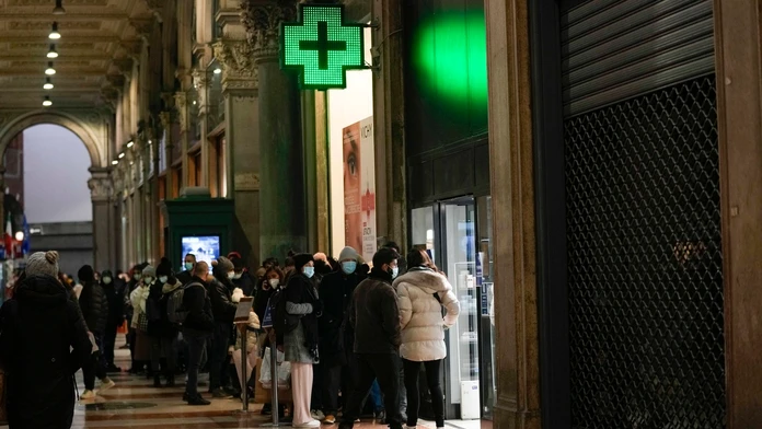 ľudia čkajú v rade pred lekárňou v talianskom Miláne.