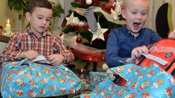 Deti rozbaľujú vianočné darčeky.