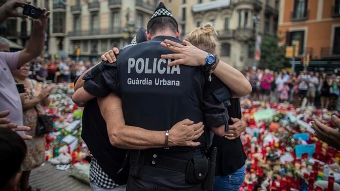Policajt objíma chlapca s rodinou, ktorým pomohol počas teroristického útoku.