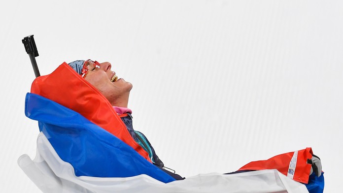 Anastasia Kuzminová sa teší v cieli po zisku zlatej olympijskej medaily počas pretekov žien s hromadným štartom na 12,5 km.