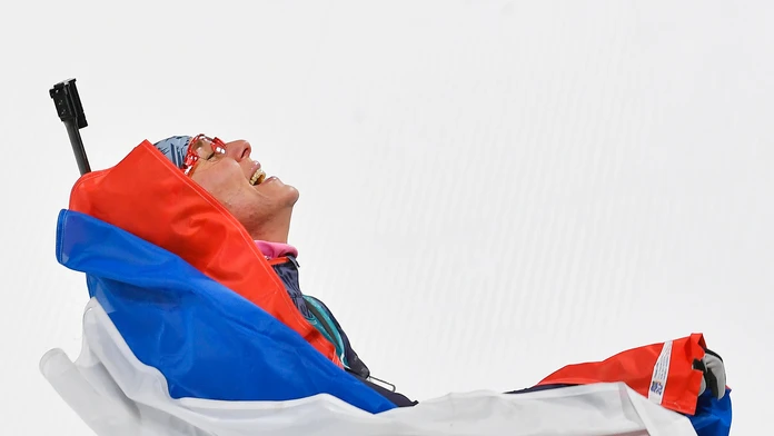 Anastasia Kuzminová sa teší v cieli po zisku zlatej olympijskej medaily počas pretekov žien s hromadným štartom na 12,5 km.