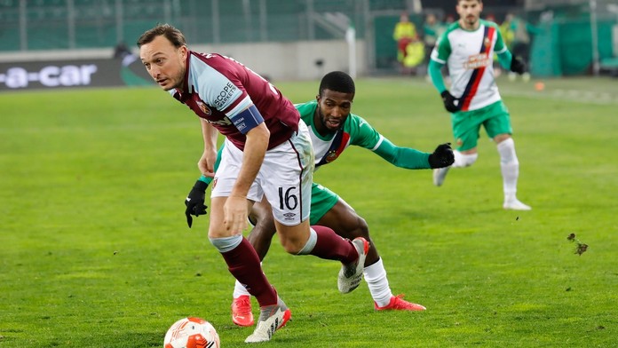 Mark Noble (West Ham) v súboji o loptu s Kelvinom Arasem z Rapidu Viedeň.