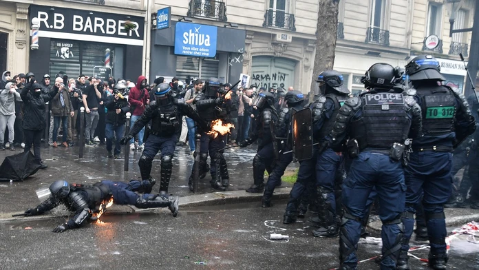 NA snímke sú zachytené demonštrácie vo Francúzku. Na fotke sú demonštranti aj policajti. Jeden z policajtov leží na zemi.