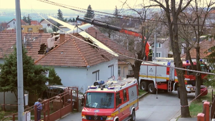 Hasiči dávajú dole zo strechy vetroňa, ktorý pristál na streche domu na Zobore.